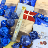 Blå farsdagsgavekurv med håndlavet keramikflag fra Speedtsberg, chokoladetrøfler, vingummi og chokoladekugler