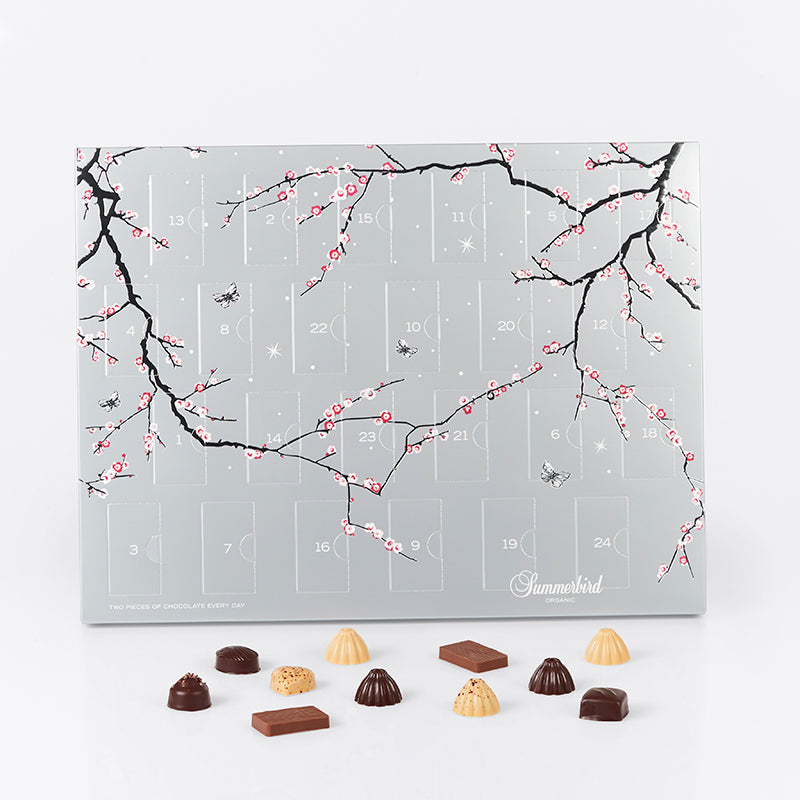 Summerbird signaturjulekalender i sølvdesign med 24 låger, hver med 2 økologiske chokolader i mørk og Amber-variant.
