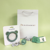 Sød grøn gavepose til barsel eller babyshower med babystrømper fra MP Danmark, FRIGG sut str. 1, Mushie bidering og chokoladekugler