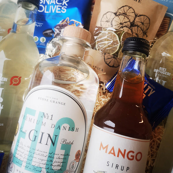 Ultimativ gavekurv til én, der elsker Gin Hass. Stor flot gavekurv med en flaske dansk gin fra Elg gin, dansk lemon brus fra Bie's Bryggeri, dansk økologisk mango sirup, frugtskiver og en masse krydrede snacks