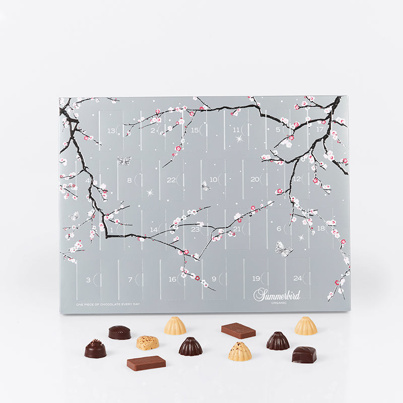 Summerbird julekalender i elegant sølvdesign med 24 låger fyldt med økologiske chokolader i 12 varianter, inkl. marcipan, ganache og små barer.
