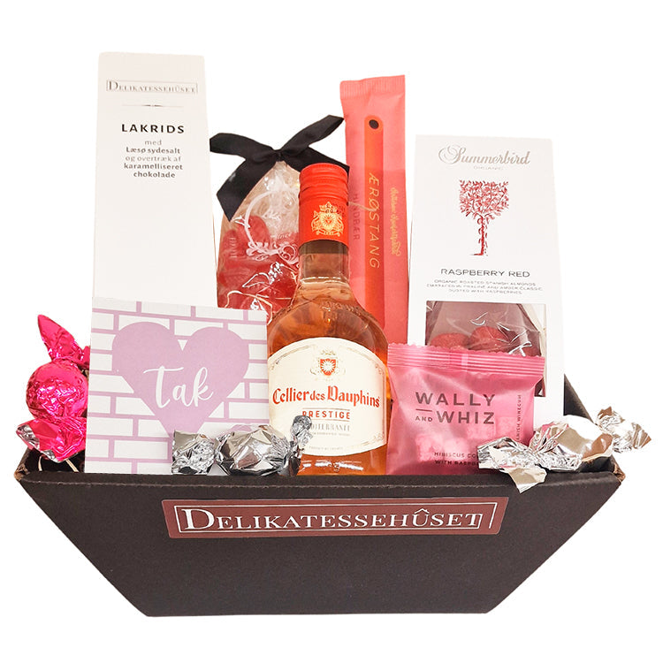 Sød feminin gavekurv med lille flaske fransk rosévin, chokolade, lakrids, mandler vingummi m.m.